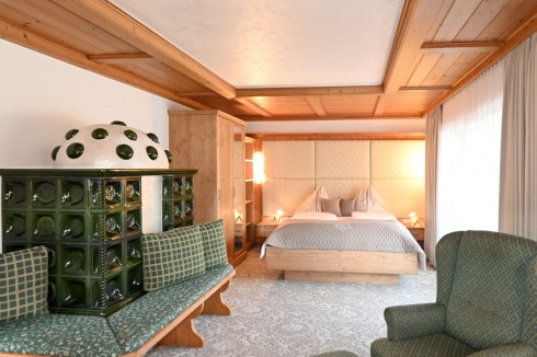 Bett und Kachelofen im Appartement Dachstein in Schladming