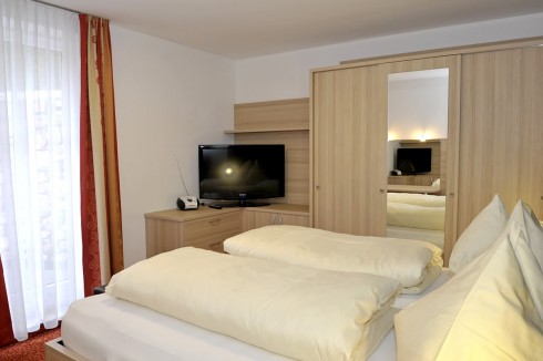 Schlafzimmer mit großen Kleiderschrank und TV.