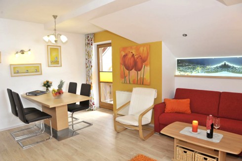 Wohn- und Essbereich mit Couch in der Ferienwohnung Reiteralm